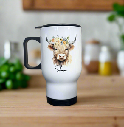 Travel mug with a cow design and the name 'Sharon' on a wooden surface.